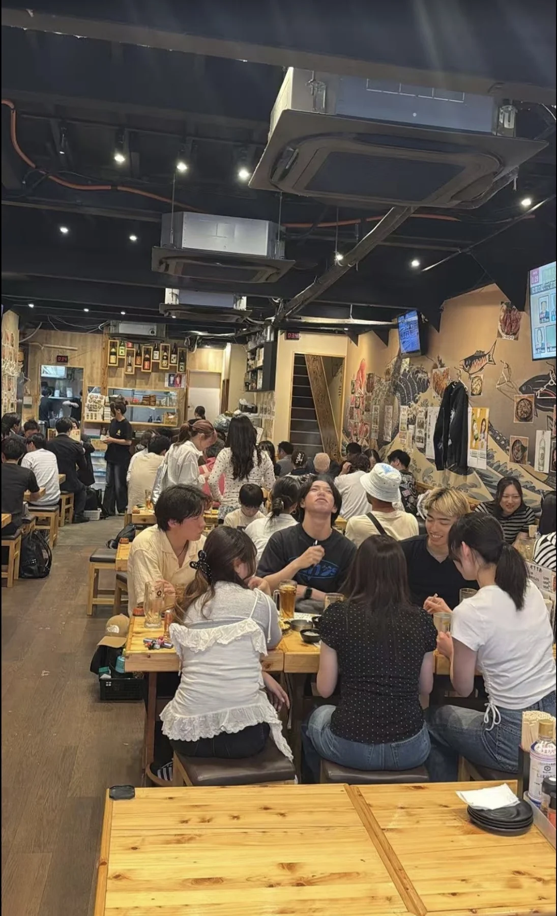 魚吉酒場 上野店の木のテーブルと店内