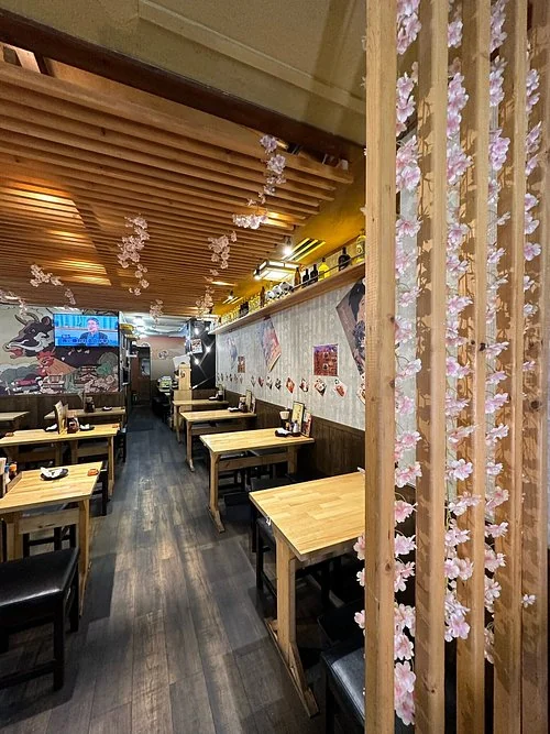 大将 上野店の木のテーブルが並ぶ店内